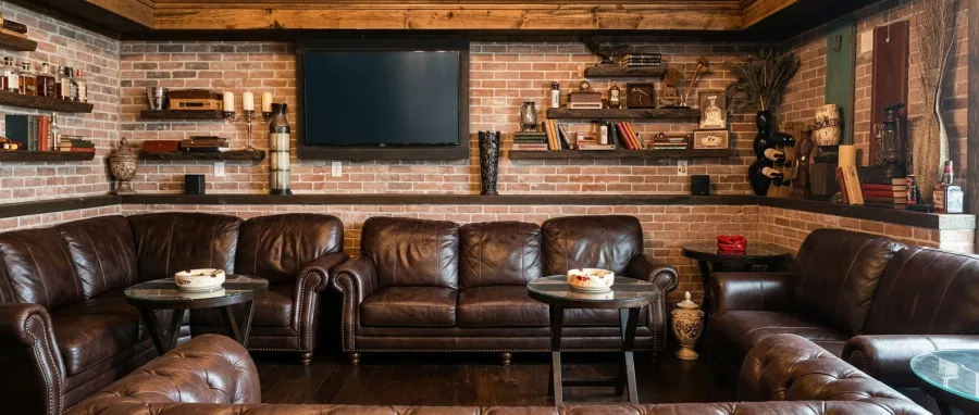 The main indoor lounge with brown leather club chairs and a wall-mounted television